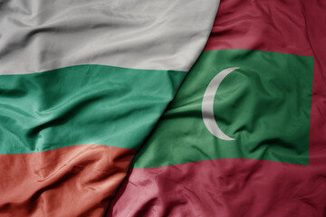 Fototapeta premium big waving national colorful flag of maldives and national flag of bulgaria .