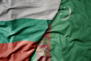 big waving national colorful flag of turkmenistan and national flag of bulgaria .