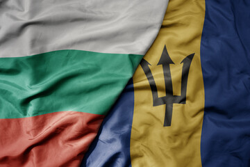 big waving national colorful flag of barbados and national flag of bulgaria .