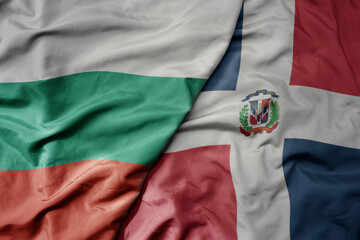 big waving national colorful flag of dominican republic and national flag of bulgaria .