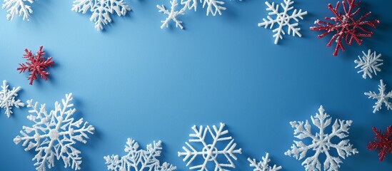 Elegant Blue Background with Red and White Snowflakes in Winter Season Celebration