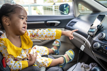 Little girl enjoying sit on car seat fasten belt - 740364706