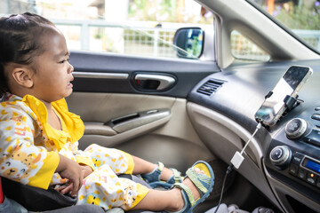 Little girl enjoying sit on car seat fasten belt - 740364724