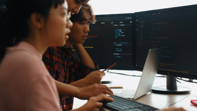 Slow motion back end software developer engineer for computer programming working together on debugging writing computing code, solving complex algorithms display on monitor in office. Burgeoning