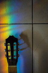 Música. Clavijero de Güitarra acustica con rayo vertical multicolor cayendo sobre el. Vertical.