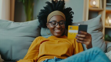 Happy, black woman and credit card with phone on sofa for online shopping, payment code and fintech at home. Mobile banking, finance and password to upgrade subscription, ecommerce and money savings