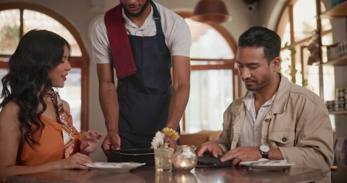 Waiter, restaurant and couple with menu, man and woman at table on date Italian cuisine with wine. Dining, serve and decide at bistro with meal, dessert and people for dinner on valentines day