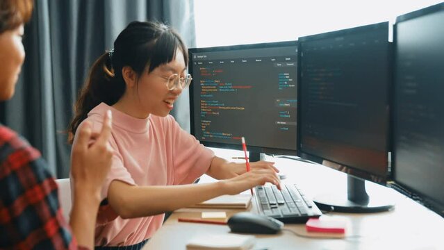 Slow motion back end software developer engineer for computer programming working together on debugging writing computing code, solving complex algorithms display on monitor in office. Burgeoning