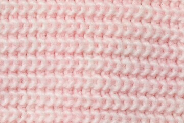 Texture of soft pink knitted fabric as background, top view