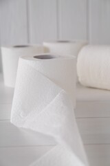 Soft toilet paper rolls on white wooden table