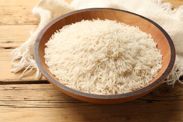 Raw basmati rice in bowl on wooden table
