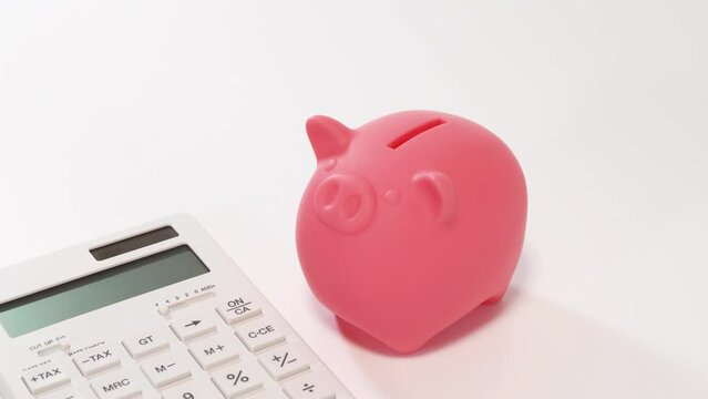 ブタの貯金箱にコインを入れる手