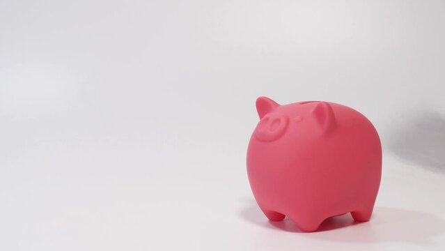 ブタの貯金箱にコインを入れる手