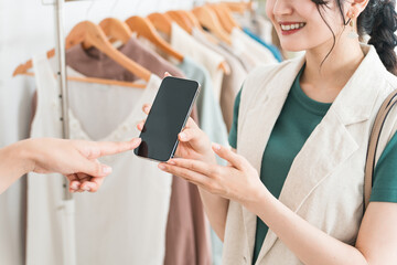 スマホ・スマホ決済・オンライン決済で買い物をする女性とショップ店員
