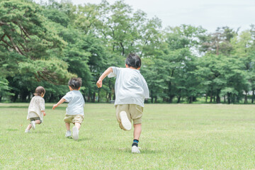 公園で追いかけっこする活発な子供達・兄弟・走る・短距離走
