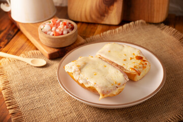 Molletes. Mexican recipe based on bolillo bread split lengthwise, spread with refried beans and gratin cheese, adding pico de gallo sauce and some protein such as ham, bacon or chorizo.