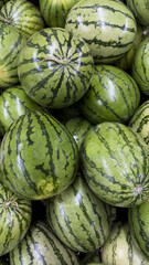 Watermelons background, a natural mosaic of freshness and flavor. Nature's Patterns, the Intricate Beauty of Stacked Watermelons. Abundance of freshness, a glimpse of the summer harvest