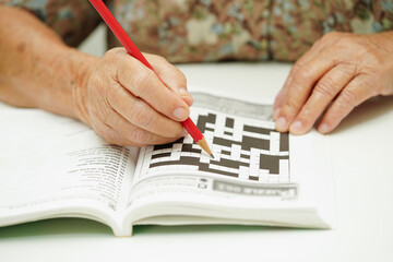 elderly woman playing sudoku puzzle game for treatment dementia prevention and Alzheimer disease.