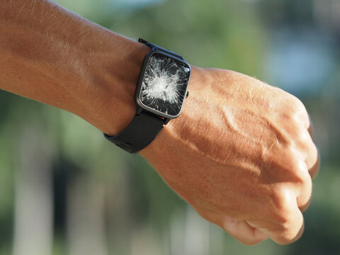 Hand with smart watch with broken touch screen. Close-up.