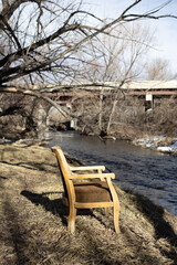 wooden chair on the river bank