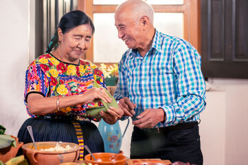 Happy indigenous grandparents make tamales, a traditional dish for Saturdays and Christmas.