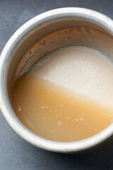 organic arrowroot rhizomes settled starch-water mixture, with the heavier starch particles sinking or collect in the bottom, process of making powder, used as gluten free alternative, selective focus