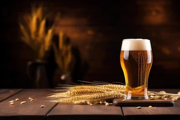  A glass of beer and spikelets of barley on a wooden table. Blurred background. © MadMouse