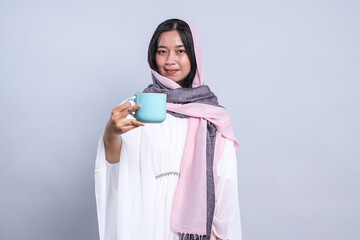 Young Female Teenager Wearing Veil Offering a Mug of Water to Keep Healthy at Ramadan Month 