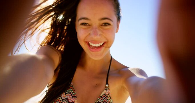 Woman, smiling and laughing in selfie at beach, travel influencer and pov while live streaming. Female person, low angle and confidence on vlog, internet connection and portrait on vacation in Miami