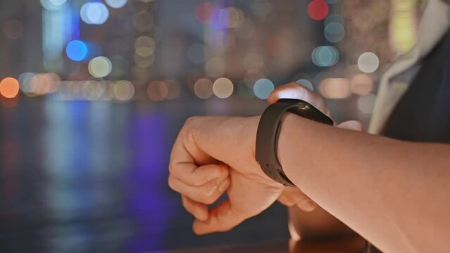 closeup view of smartwatch on and of male user in evening time outdoors, man adjusting app