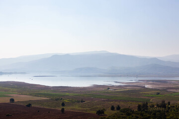 Obraz premium Doi Tao Lake and mountain view in North Thailand. Beautiful landscape with water, forests, and clear skies.