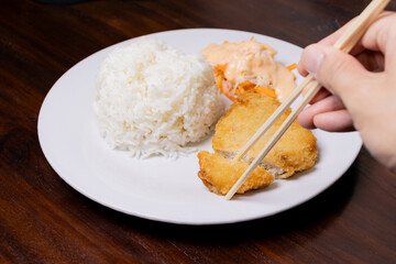 Rice with chicken katsu in white plate on wooden table. After some edits.