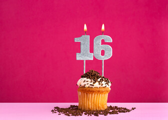 Birthday cupcake with candle number 16 - Birthday card on pink background
