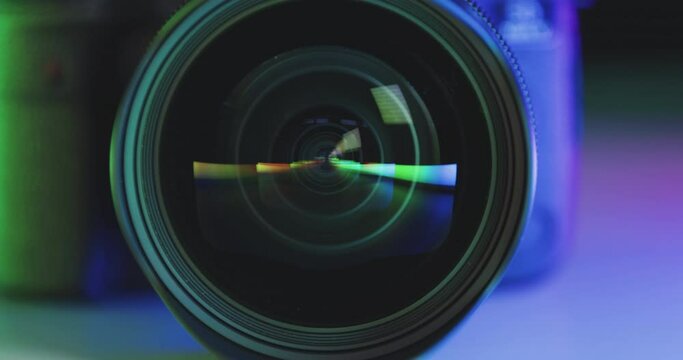 Lens of photo camera reflects colorful rainbow colors prism in glass, slow camera movement
