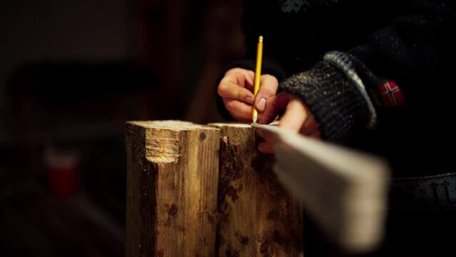 A Man is Utilizing a Folding Yardstick to Gauge and Indicate the Wood - Close Up
