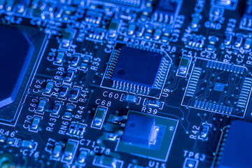 computer circuit board with chips and different electronic components. toned blue. closeup view.