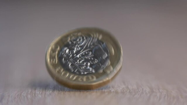 one pound coin fall in depth of field shallow focus and stop spinning