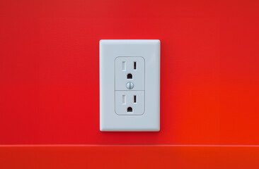 American Electricity Outlet with Saftey Features on a Red Wall