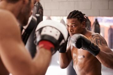 Men, coach and martial arts with combat training in fight, gloves and partner for punch at gym....
