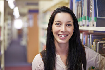 Smile, student and portrait of woman in library for studying at university for test, exam or...