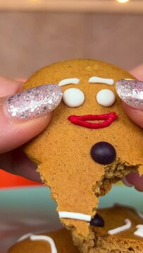 breaking the gingerbread man into different parts destroying the concept of end of life holiday holiday cookies close up in the hands of a woman. end of christmas