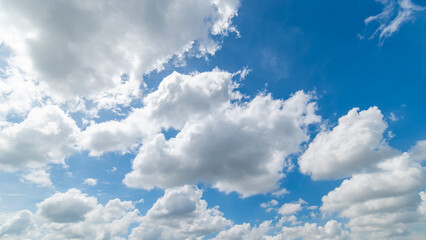Naklejka na ściany i meble Panoramic view of clear blue sky and clouds, Blue sky background with tiny clouds. White fluffy clouds in the blue sky. Captivating stock photo featuring the mesmerizing beauty of the sky and clouds.