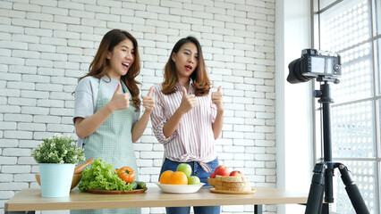 Two Asian influencer vlogger live review healthy lifestyle together. Two Young Women Friends blogger vlog Happy Lifestyle greeting Live Streaming. Vlog two women talk social media say hello broadcast - obrazy, fototapety, plakaty