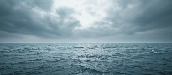 Papier Peint photo Lavable Réflexion Majestic and ominous dark ocean with turbulent dark clouds reflecting on the water surface