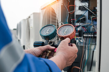 Technician is checking air conditioner,measuring equipment for filling air conditioners.