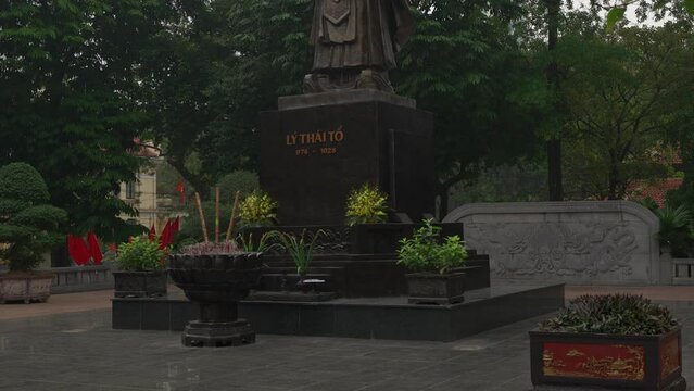 Tilt up reveal of the wise looking Ly Thai To with scroll in hand. Bronze statue in Indira Gandhi park, Hanoi.