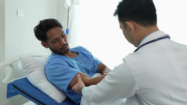 Doctor or physiotherapist doing physiotherapy work on injured arm elbow of male athlete patient, stretching and exercises, cause pain rehabilitation therapy in clinic.