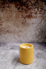 velas de soya en recipiente de concreto con fondo gris