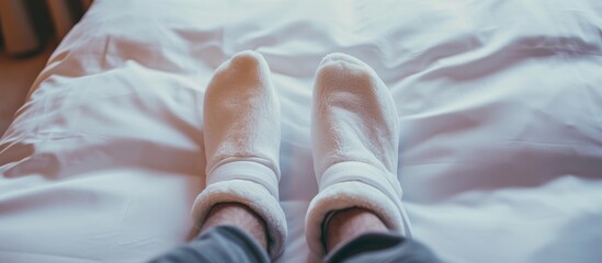Cozy feet under white sheets in comfortable bed concept for relaxation and sleep - Powered by Adobe