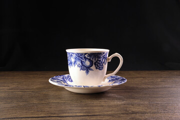 Decorated retro ceramic China English tea cup saucer on black background - 740475318